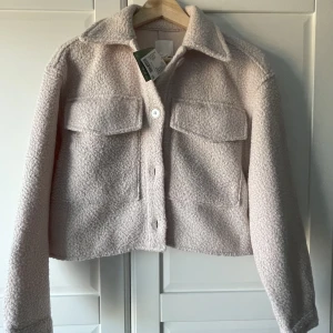 Jacka från HM med lapp kvar - Nypris 349 kr, lapp kvar. Oanvänd. Jättefin kort höstjacka! Ljus vitbeige.