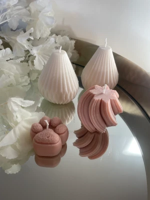 Fyra ljus i olika former - Två vita ljus i ”päronform”, ett beige/rosa ljus i tassform och ett beige/rosa skruvat ljus. Hemmagjort. Gorda av sojavax och återvunnet stearin. 