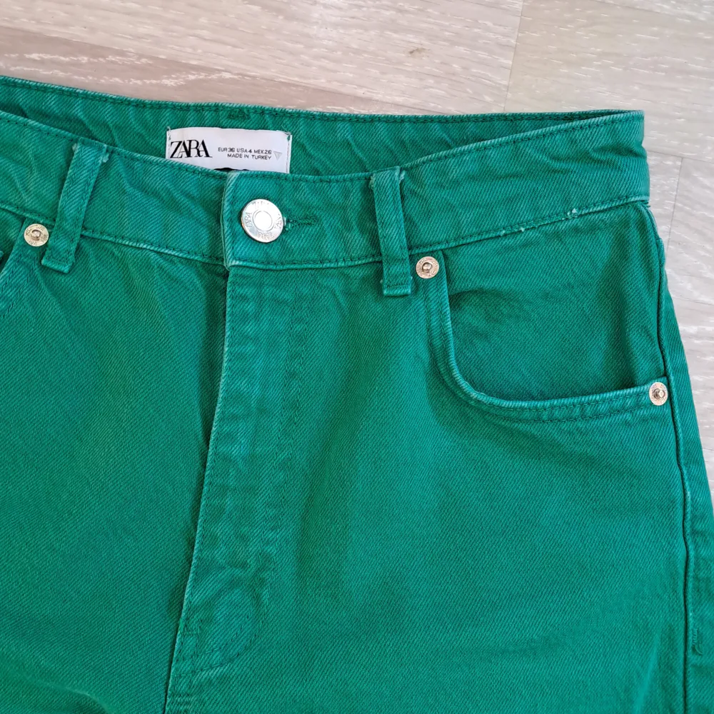 Intensivt gröna högmidjade jeans från zara. Fransiga i benslutet, långa i benen.  Midja 72cm Innerbenslängd 89cm. Jeans & Byxor.