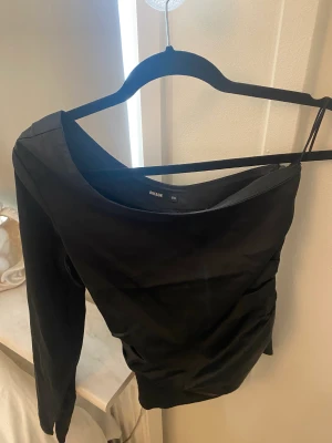 Festtopp - Jättefin tröja långärmad på ena sidan. Den är silkesmaterial. Finns dragkedja på sidan så de är lättare att ta på sig den. Jättefin att ha som festtopp