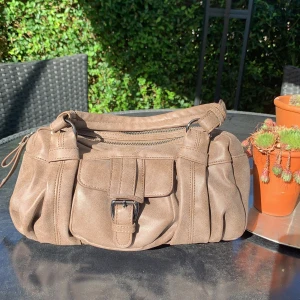 Handväska - Oanvänd brun handväska med ett ytterfack och två större innerfack. Praktisk och snygg! 