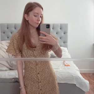 Blommig klänning  - Sommarklänning i senapsgult. Passar större byst