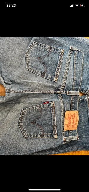Lowwaist Levis Bootcut jeans - Tidgare köpta på Vinted men var för korta på mig som är ca 170. Sömmen längst ner är sprättad, men går lätt att sy upp igen. Annars perfekt skick. Passar i midjan på mig som annars är strl S.  Bilderna från tidigare säljare, kan skicka egna vid förfrågan💕