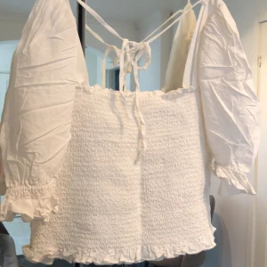 Vit tröja  - En vacker sommartröja med ribbat material och puffiga ärmar. 