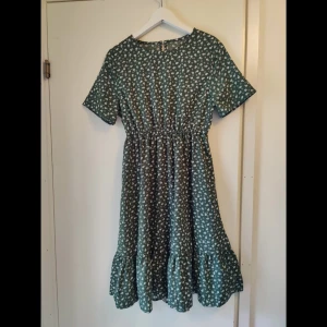 Grön blommig sommarklänning! - Superfin klänning i grönt med vita blommor. Passar fint till sommaren! 