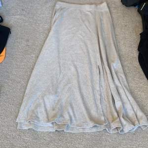 Kjol med cut  - Beige fin kjol med ett slit. Inga tecken på användning.