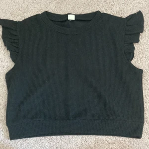 Topp - En svart topp ifrån Shein. Volang på armarna. 