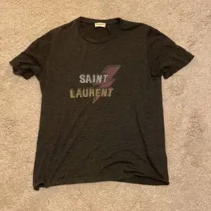 Saint Laurent tshirt i storlek XS men passar även S, tröjan är i mycket bra skick. Hör av dig om du har mer frågor.