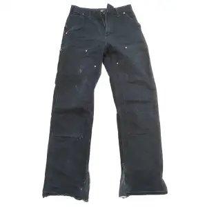 carharrt double jeans som är uppklippta på botten och klippta så att dom är bredare