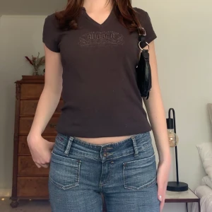 Brunsvart t-shirt - T-shirt/babytee i brunsvart färg med en broderad text och unik urringning, originellt från Gant! 🤎