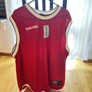 Spalding Top (röd/vit)  - Spalding team gameset i strl XL, aldrig använd, prislapp sitter kvar. Originalpris: 499:- Mitt pris: 150 SEK. 