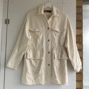 Cremevit jeansjacka - Går att knyta åt i midjan samt fransdetaljer nedtill samt på fickorna 😍 använd endast en gång, superfint skick!! ✨
