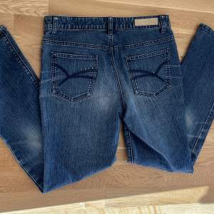 Medel/högmidjade blå jeans från isolde med lite rhinstones och broderier på bakfickorna. Jätte bra skick!! Midjemått:38cm rakt över,innerbensläng:73cm