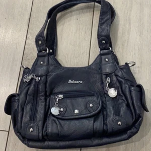 Y2k handvöska - Cool handväska med många detaljer och fickor i bra skick☺️Medföljer en strap så man kan ha den som en crossbody också om man vill! Mått: ca 28x20 cm. Det mga intresserade så det är fullpris som gäller. Använd gärna köp nu knappen☺️ 