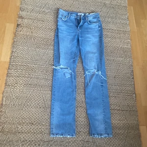 Blåa jeans - Hål vid båda knäna del av modellen 