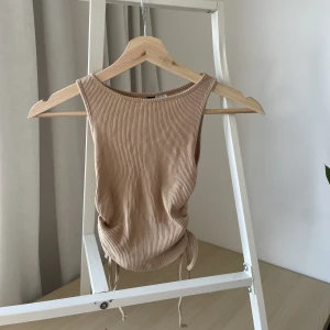 Croppad topp  - Beige croppad topp med snöre på sidan. Nyskick!