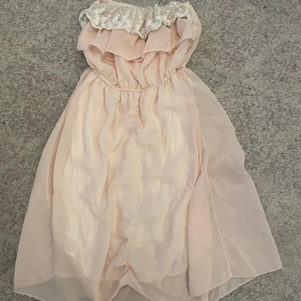 En rosa jätte gullig klänning med vita volanger på och den är stretchig och köparen står för frakten och har använt den typ 4 gånger så den är i bra skick . Klänningar.