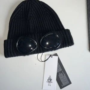 Cp company mössa  - Snygg och stilig mössa från cp company som håller dina öron varma under vintern.  Scan fungerar. Nyskick bara testad. Säljes pga jag gillar inte hur jag ser ut i den. Självklart äkta