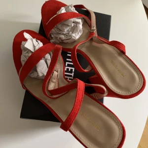 Klackskor - Säljer dessa fina röda klackarna från prettylittlething. Helt oanvända då det tyvärr var fel storlek för mig. Det är storlek 41 men skulle inte säga att de är som vanliga 41or. Köparen får med originalkartongen & påse till varje sko. 