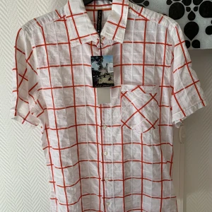 Skjorta Nudie Jeans Co M - Oanvänd kortärmad herrskjorta från Nudie Jeans Co i strl M. Prislappen finns fortfarande kvar.