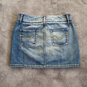 Vintage y2k jeanskjol - Sååå snygg vintage jeanskjol!! Perfekt färg och coola detaljer med gula sömmar och snygg knäppning!! As nice till sommaren. Står strl 40 men passar även mindre storlekar om man vill ha den lågmidjat!!💚💚