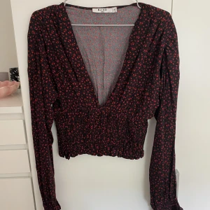 Blommig blus - Superfin blus från NA-KD. Aldrig använd så i nyskick. Superfint mönster med fina detaljer. Skicka för bilder hur den ser ut på. 