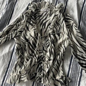 Festtopp  - Så snygg topp från NAkd i zebra mönster. Perfekt festtopp med en bralette under. 