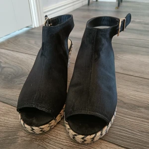 Högklackade skor  - Högklackade skor från River Island med flätad sula. Storlek 4/37. Öppen häl, knäpps med knäppe. Klackhöjd 7 cm.  Köpta begagnade men jag har aldrig använt dom pga för stora.  I fint skick!