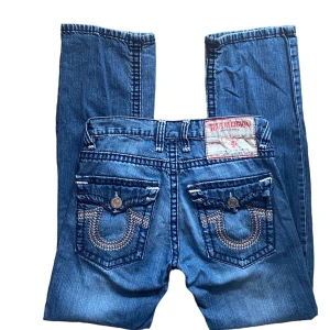 true religion jeans - snygga raka midwaist true religion jeans som dessvärre är för långa för mig så måste sälja vidare.😢Bra skick förutom översta knappen är borta. Men går lätt o fixa ny. Skriv privat för fler bilder, o mått. Köparen står för frakt. Använd gärna ”köp nu” <3 