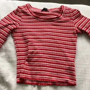 Tröja med utsvängda ärmar - Tröja från monki med utsvängda ärmar. Rosa, röda och vita ränder.  Har knappt använt den. Säljer pga för liten