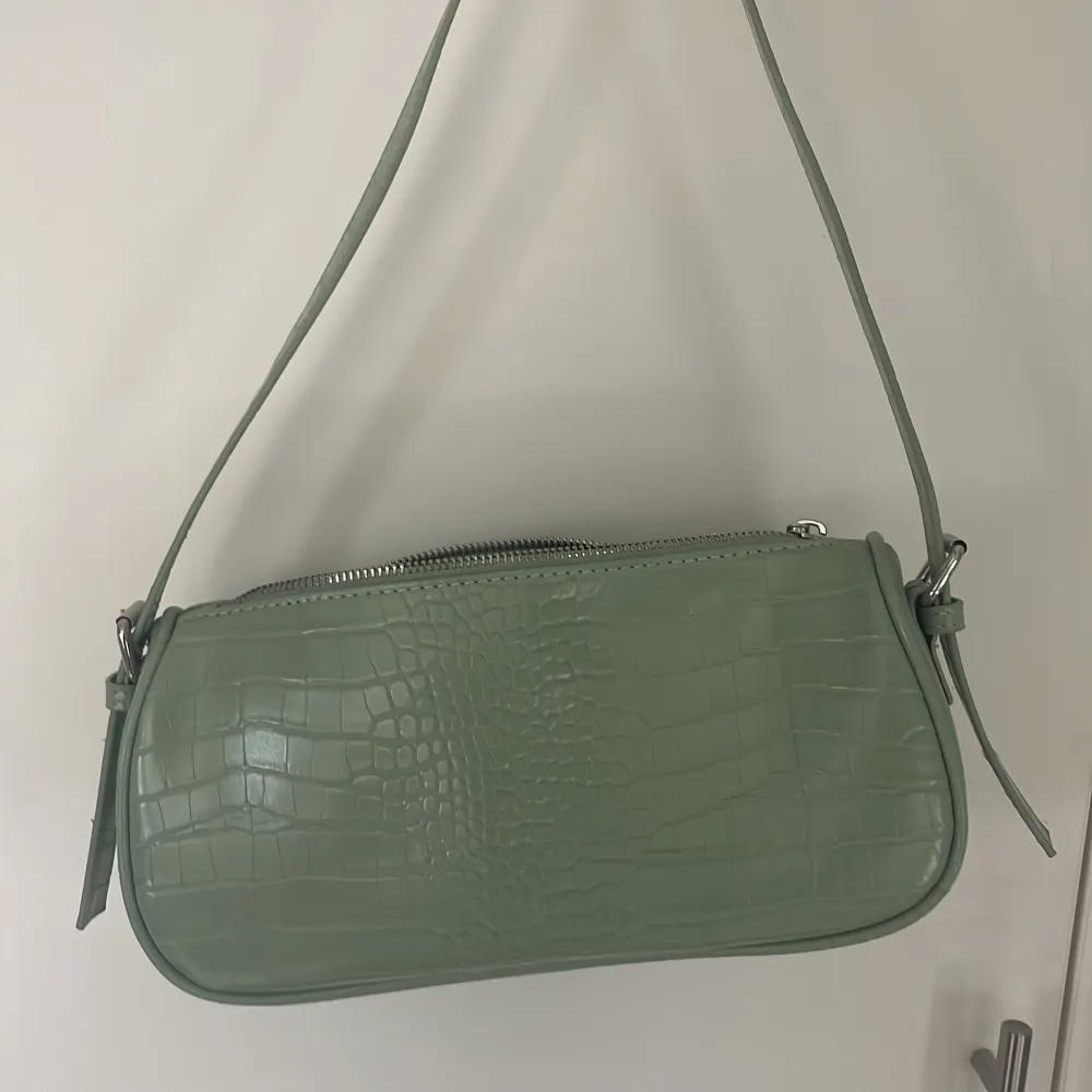 Grön väska från Gina tricot. Färgen är som på den första bilden, använde bara den andra bilder för att se mönstret tydligare🥰Säljer för den inte kommer till användning!. Accessoarer.