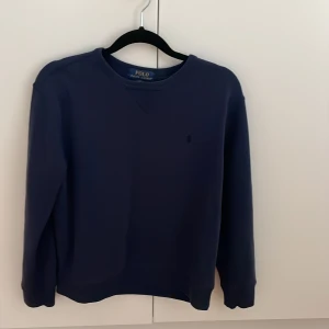 Ralph Lauren Tröja - Polo Ralph Lauren sweatshirt. En stilren tröja i mörkblå färg. Storlek L i barnstorlek (14-16 år), Passar runt 165-175cm. Den är i nyskick.