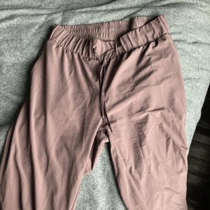 Mjukisar i träningsmatrial - Dessa sköna byxor från Athlecia är använda fåtal gånger och är i storlek 40. Byxorna är en blandning mellan plommonlila och bruna.
