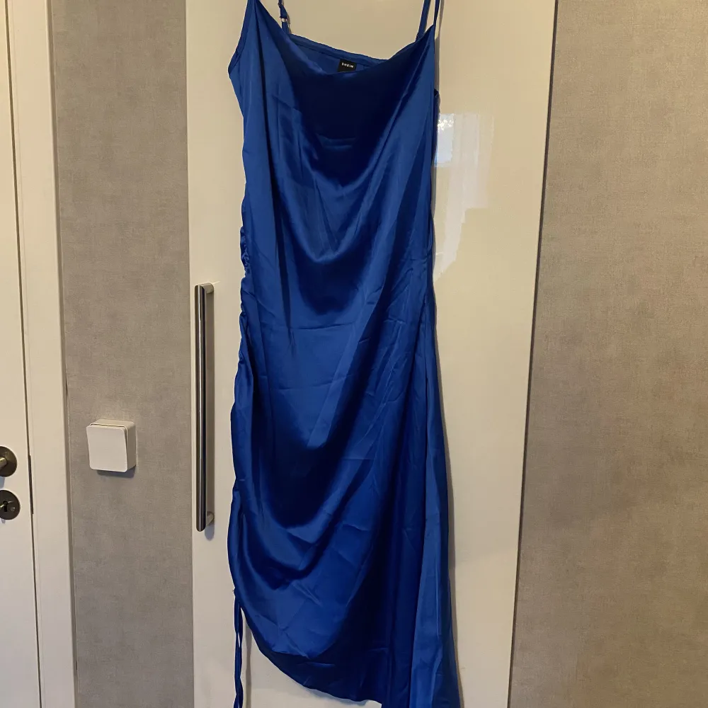 Blå satin klänning med åtdragnings snöre vid sidan, köpt från SHEIN, fin kvalite och aldrig använd endast testad. Storlek M Köptes för 119, säljes för 60. Klänningar.