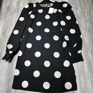 Klänning - En ny klänning aldrig använd från H&M, med puffa armar och prickiga mönster. Klänningen är i storlek CS men kan passa också som S.