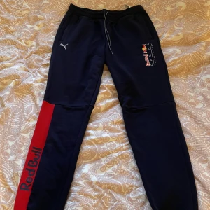 Redbull racing mjukisbyxor puma - Säljer dessa oanvända redbull racing mjukisbyxor då dom inte används. Dom är i gott skick och har snörning vid midjan samt fickor med dragkedjor. Väldigt bekvämt material och fina tryck som inte har några som helst defekter. 