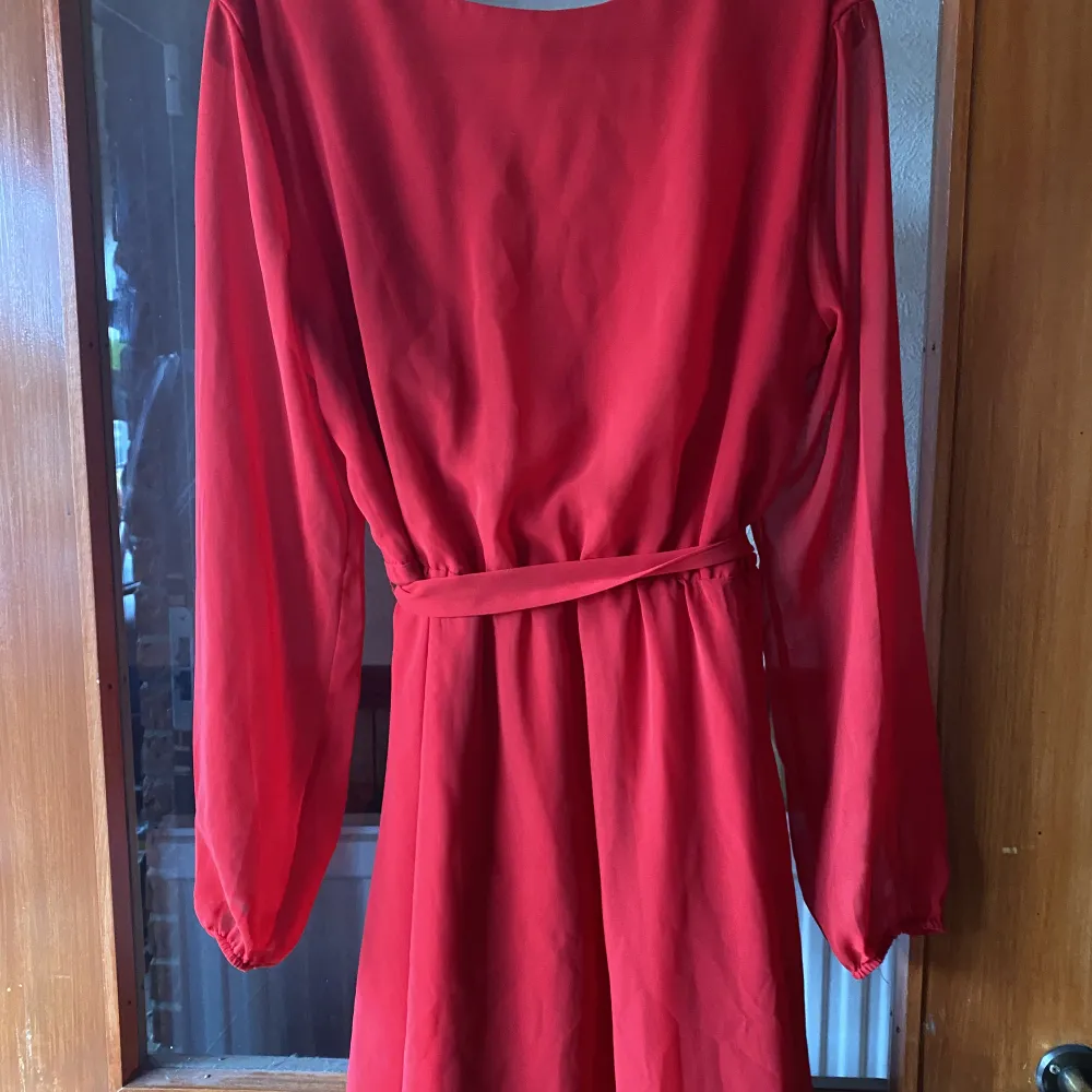 Jätte fin röd långärmad klänning med snöre den är hel å i jättefint skick då den knappt är använd  det ända som skulle behövas fixas är den högra öglan till snöret då den börjat släppt lite !🤍finns ingen lapp i klänningen men strl är s/ m . Klänningar.