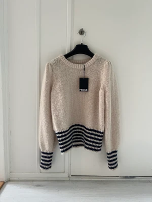 Stickad tröja från pieces  - Fin, mjuk stickad tröja från pieces! Den är enkel med lite ränder på armarna och längst ner. 