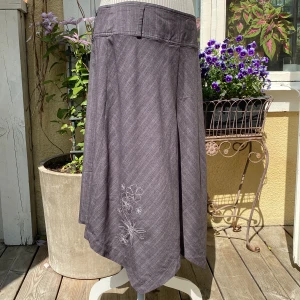 Midi kjol - Michelle - En oanvänd kjol köpt second hand i Köpenhamn från 90-talet.  Den har tunna vita ränder och ett fint broderi på framsidan. Den har en lite trög dragkedja men det går att dra upp den. Annars i mycket bra skick. 