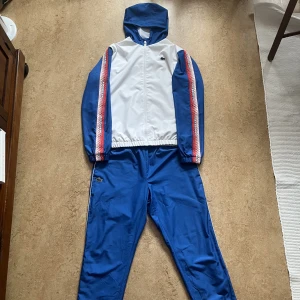 Lacoste tracksuit  - Hej säljer min blå Lacoste tracksuit som jag fick i present och aldrig har använt Den är helt ny endast testad den luktar till och med nytt  Köpt för 2600kr säljer för 1500 Size L men passar visa med M Skriv för fler bilder eller frågor