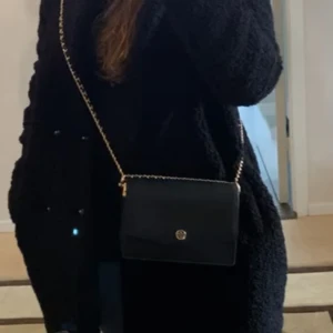 Tory burch - Säljer min svarta Tory Burch väska som är köpt för ca 2500kr men säljer för endast 700kr. Använd under ungefär 1 årstid. Fler bilder kan skickas om det önskas