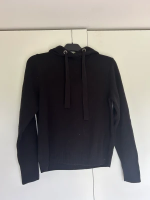 hoodie  - En svart stickad hoodie som aldrig är använd 