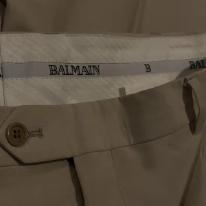 Balmain Kostymbyxor 46 - Stilrena kostymbyxor från Balmain i storlek 46, väldigt bra skick.  En minimal och nästan osynlig fläck. Vet inte vad jag ska sätta för pris så ni får komma med bud
