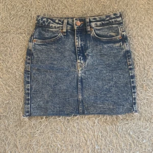 Jeans kjol - Kjol i fint skick. Högmidjad och har en blå vit färg. Andvänd ytters få gånger. 