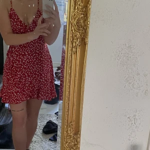 Sommarklänning - Röd sommarklänning med vita små hjärtan, volanger och omlottklänning. Pris kan diskuteras vid smidig affär