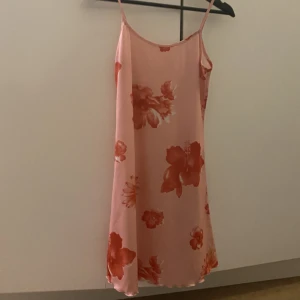Blommig klänning🌸 - Rosa klänning med röda blommor! Vet inte riktigt storleken men skulle säga S