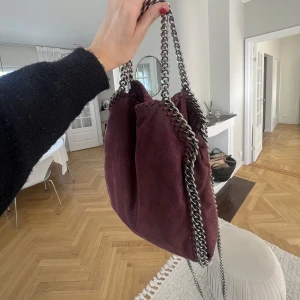 Stella McCartney MINI - Säljer min unika röda Stella väska! Väskan är jätte fin dock lite sliten och lite rostig på kedjan! Har ingen dustbag då jag köpte den här på Plick men den är ÄKTA! Kan mötas i Sthlm! Säljer för runt 3500❤️❤️