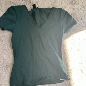V-ringad t-shirt  - Jättefin grön topp med v-ringning som man även kan ha där bak om man har tröjan bak och fram. Använd fåtal gånger och är i bra skick. Storlek m men är väldigt liten i storleken så passar även s/xs. Skriv om du har frågor💕