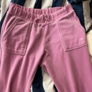 rosa juicy byxor  - Byxorna är i helt skick förutom ett fimpmärke där fram 