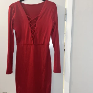 Fin lite längre klänning i röd  - Öppen vid brösten använd en gång 